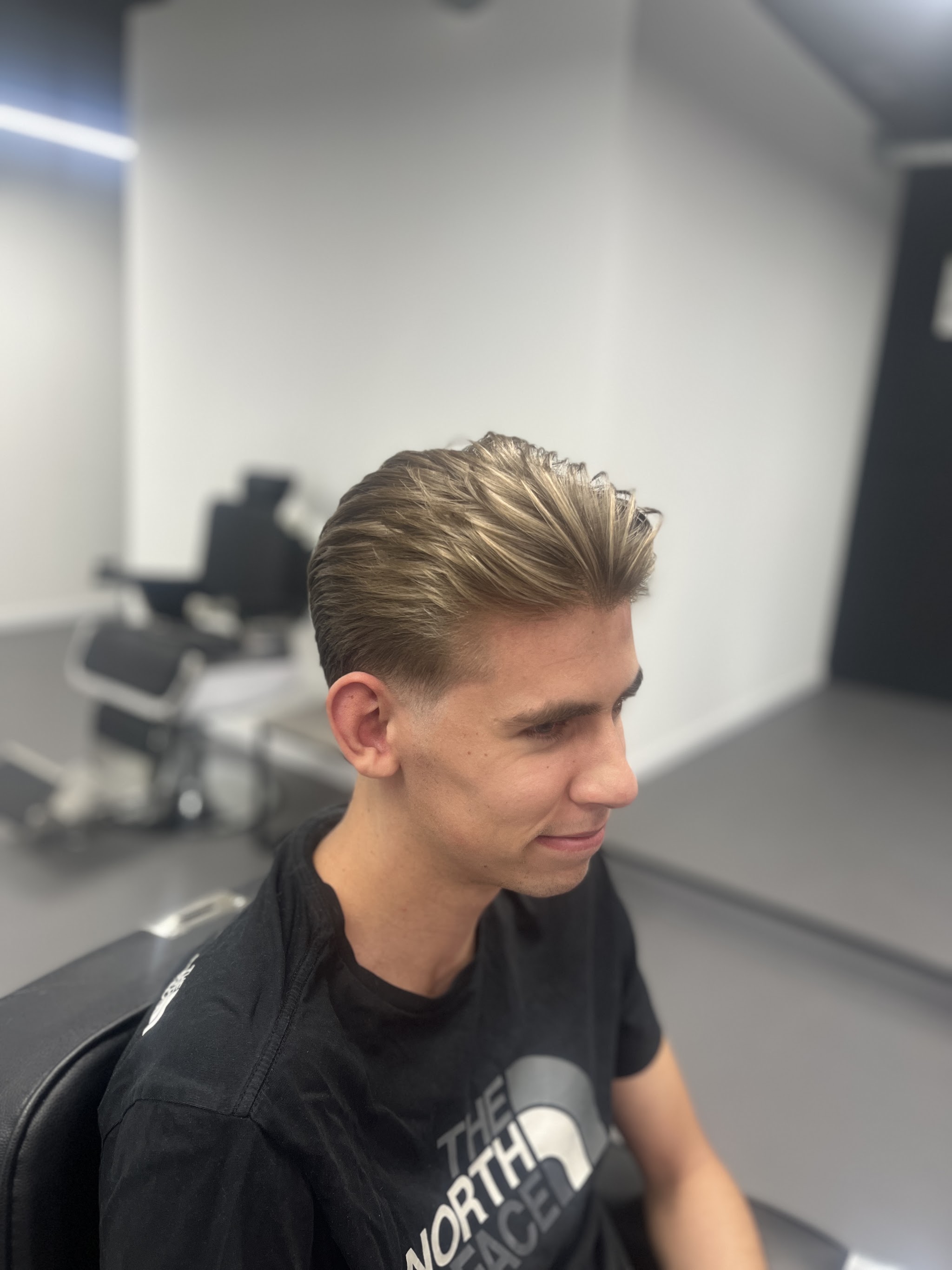 Een klant met een net geknipte coupe in de stoel bij La Sociedad